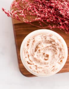 Tinted moisturizer in a glass jar with red flowers.