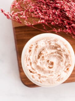 Tinted moisturizer in a glass jar with red flowers.