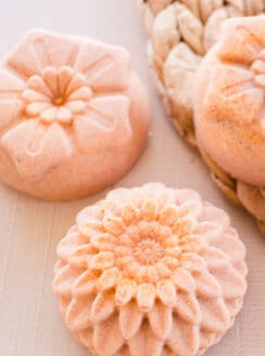Turmeric soap bars with flower top designs drying on white table.