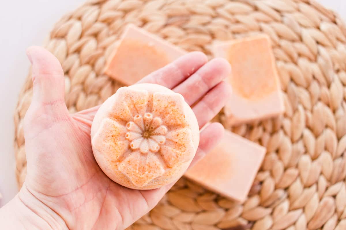 A turmeric soap bar in the palm of a hand. 