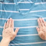 Stretching out a wrinkly shirt after spraying with a homemade wrinkle release spray.