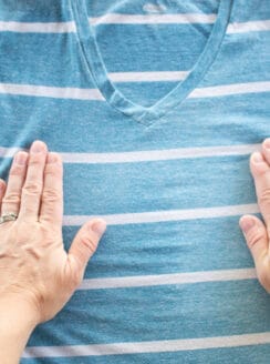 Stretching out a wrinkly shirt after spraying with a homemade wrinkle release spray.