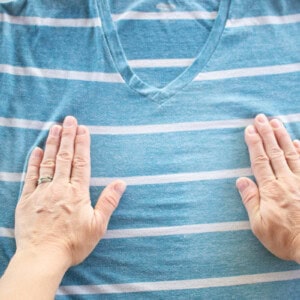 Stretching out a wrinkly shirt after spraying with a homemade wrinkle release spray.