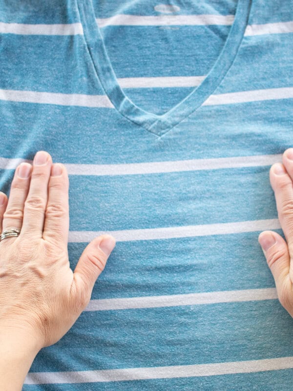 Stretching out a wrinkly shirt after spraying with a homemade wrinkle release spray.