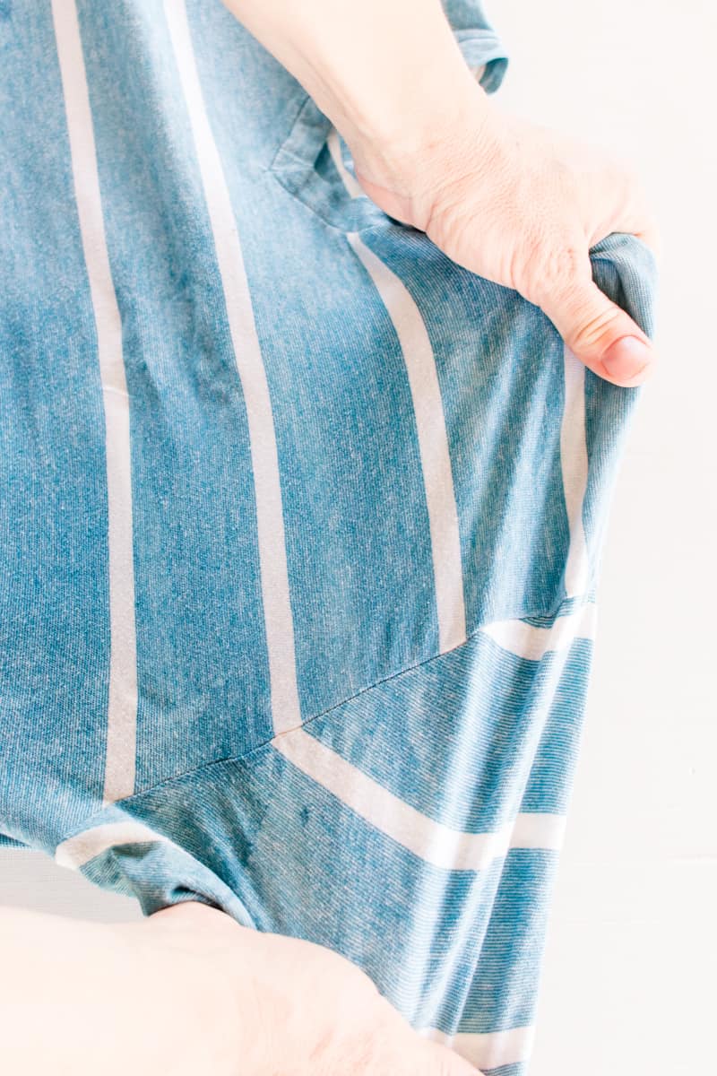 Pulling on a shirt after spraying with vinegar and water to help loosen them up.