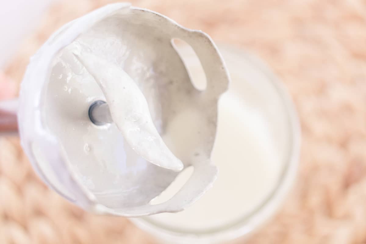 Homemade conditioner dripping off the end of an immersion blender head.