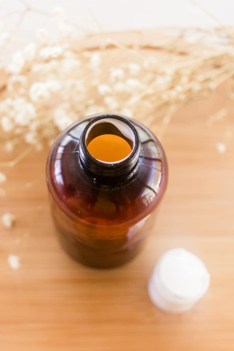 A bottle of hair conditioner on a wooden vanity.