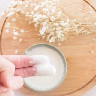 Two fingers scooping out a homemade conditioner.