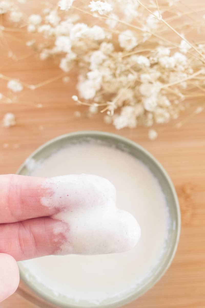 Showing the texture of the newly made hair conditioner on the tips of two fingers.