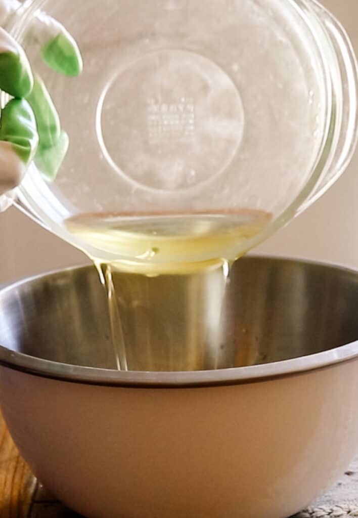 Pouring melted soap making oils into a mixing bowl.