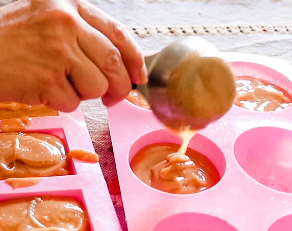 Pouring soap into the molds.