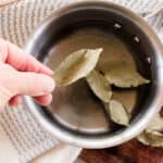 Adding bay leaves to a pot of water to boil and pour onto the hair.