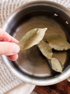 Adding bay leaves to a pot of water to boil and pour onto the hair.