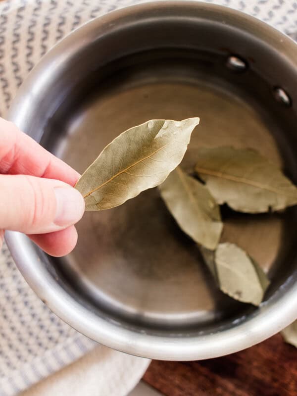 Adding bay leaves to a pot of water to boil and pour onto the hair.