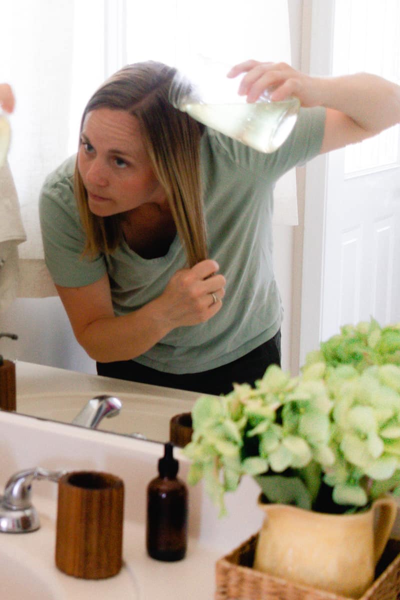 Laura putting bay leaf water onto her hair. 