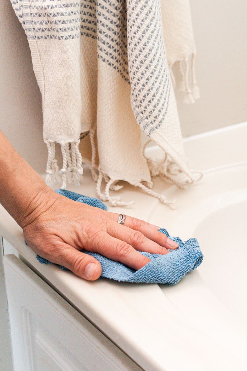 Cleaning a bathroom surface with homemade bathroom cleaner. 