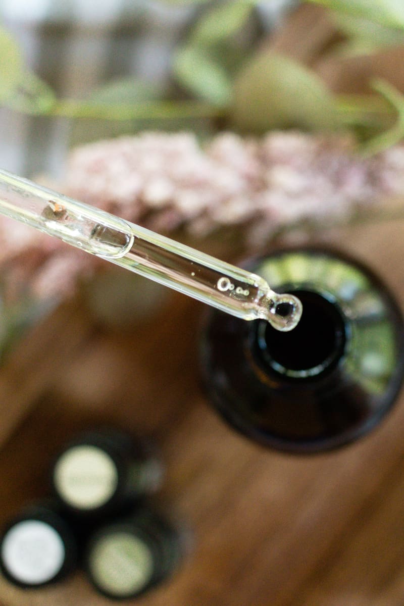 Adding essential oils to a bottle using a dropper. 
