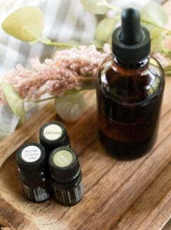 A homemade massage oil in a glass dropper bottle on a wooden table.