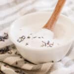 Natural hair care shampoo being stirred in a small bowl.