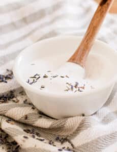 Natural hair care shampoo being stirred in a small bowl.