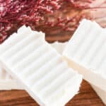 Hand cut homemade shea butter soap bars sitting on a wooden table.