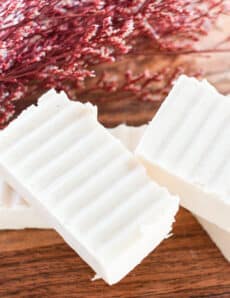 Hand cut homemade shea butter soap bars sitting on a wooden table.