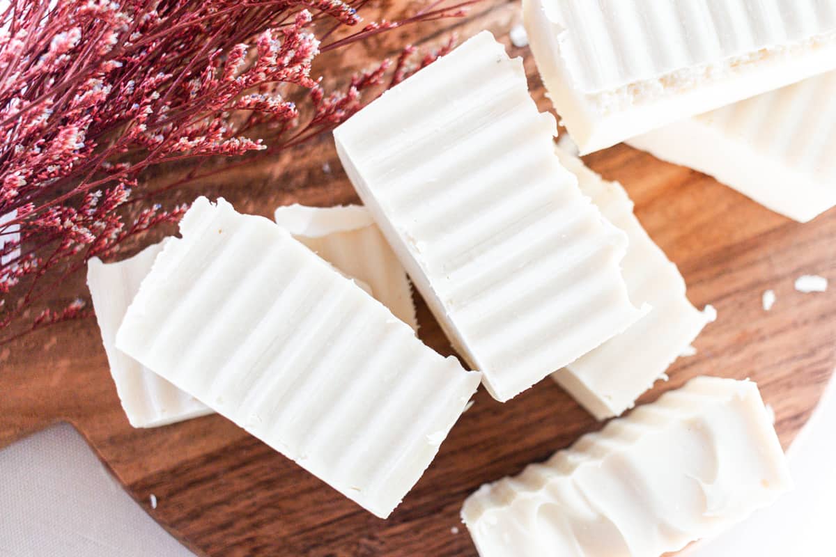 Hand cut soap bars curing on a wooden rack.