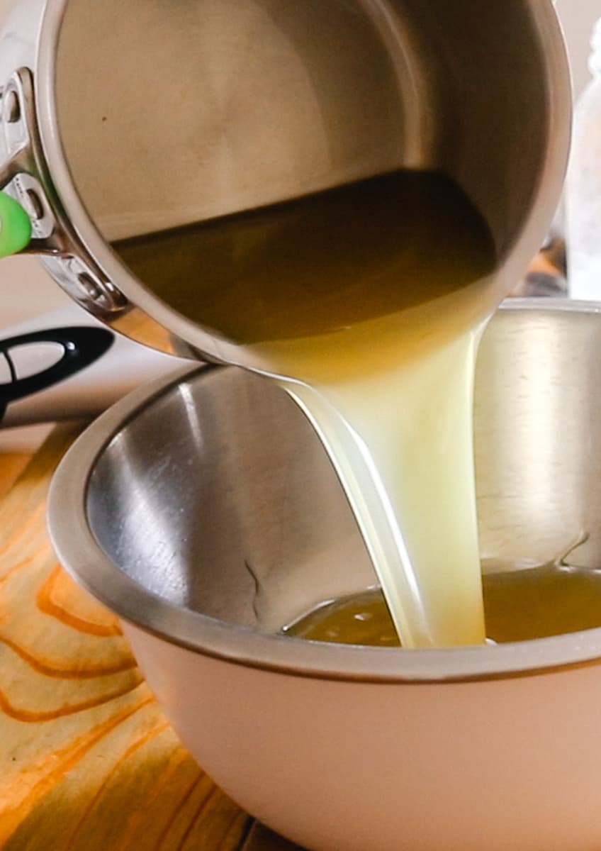 Pouring the melted fats into a mixing bowl to cool.