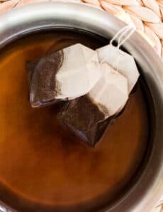 Steeping tea bags in water to make a hair dye.