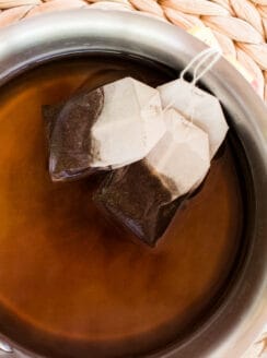 Steeping tea bags in water to make a hair dye.