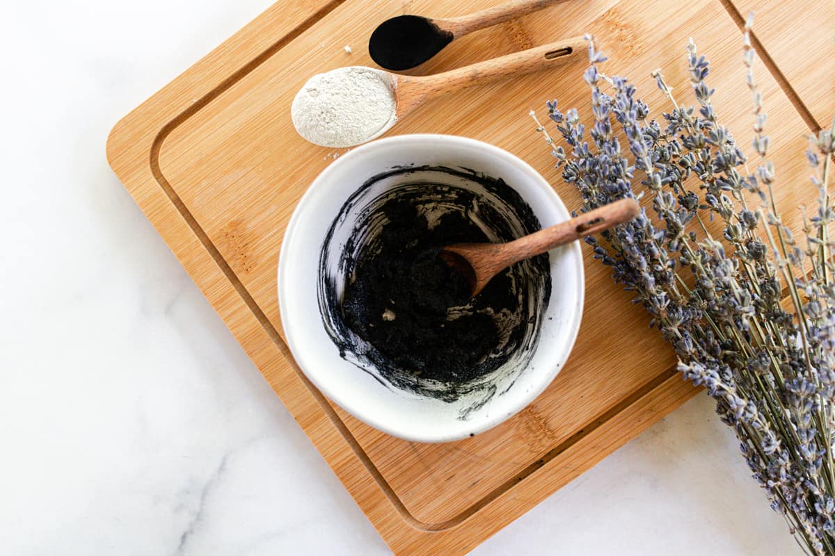 Charcoal armpit detox in a small bowl with a wooden spoon.