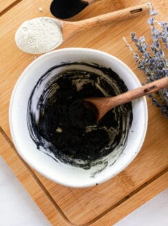 Stirring up bentonite clay and activated charcoal to make an armpit deodorizer.
