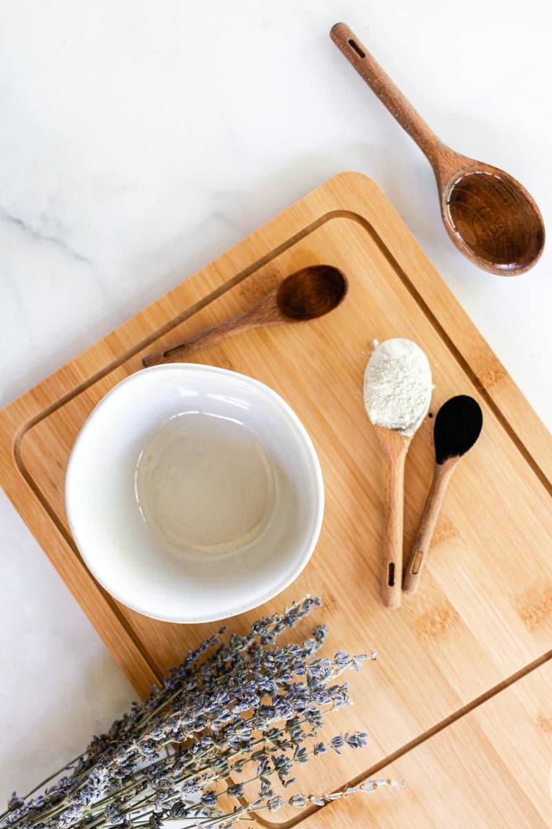 A bowl of armpit detox and its ingredients on a wooden board with spoons. 