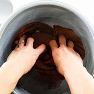 Soaking a shirt with a small mold spot in a bowl of water and vinegar.
