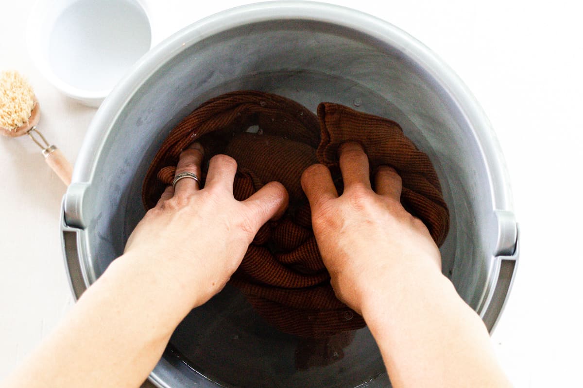 Soaking a shirt with a small mold spot in a bowl of water and vinegar.