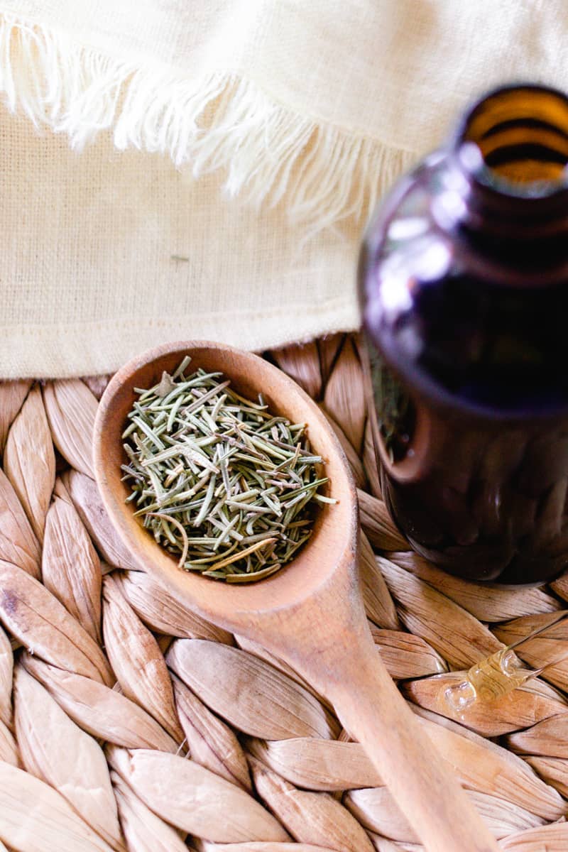 Dried Rosemary leaves and a glass bottle. 