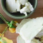 Mango butter and shea butter on a wooden tabletop.