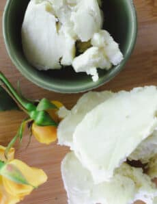 Mango butter and shea butter on a wooden tabletop.