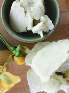 Mango butter and shea butter on a wooden tabletop.