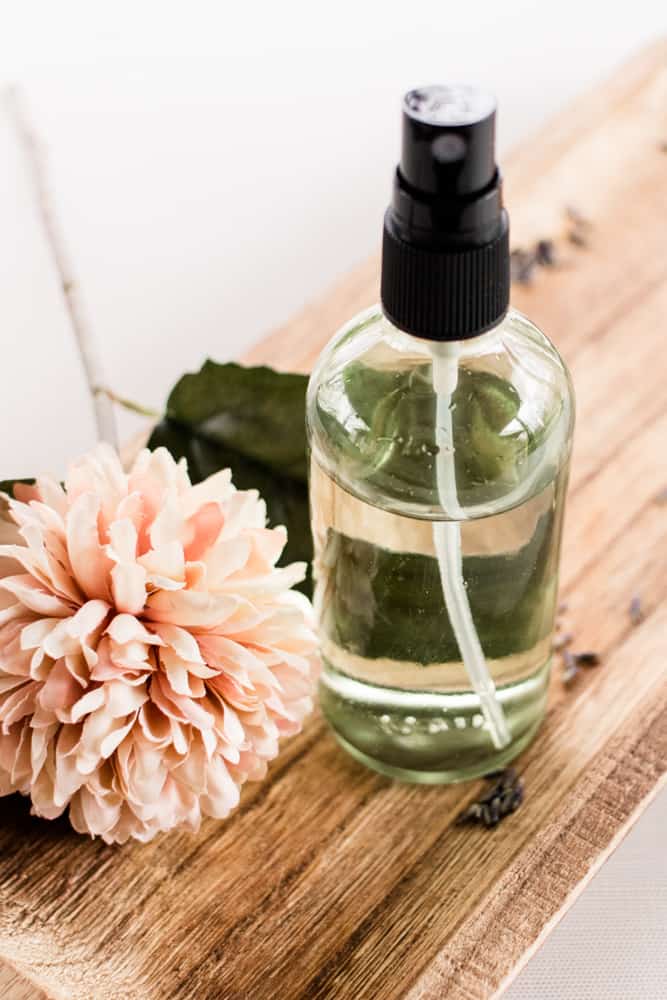 Body mist with flowers on a wooden board. 
