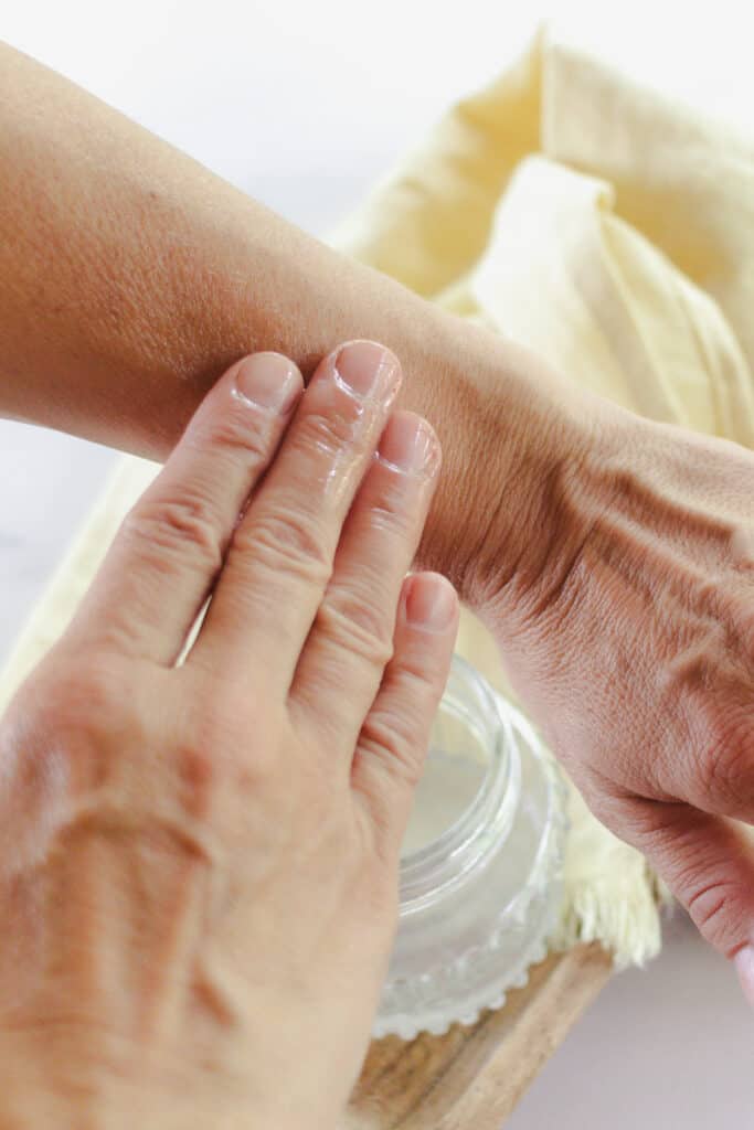 Applying tanning oil to the skin.