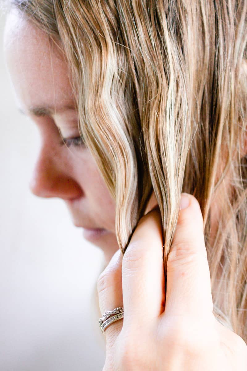 Applying homemade hair oil to her hair. 