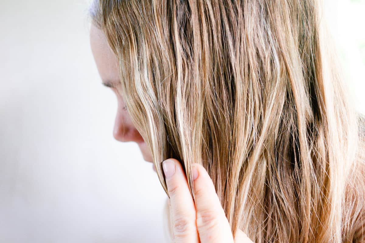 Rubbing hair moisturizing oil into my hair.