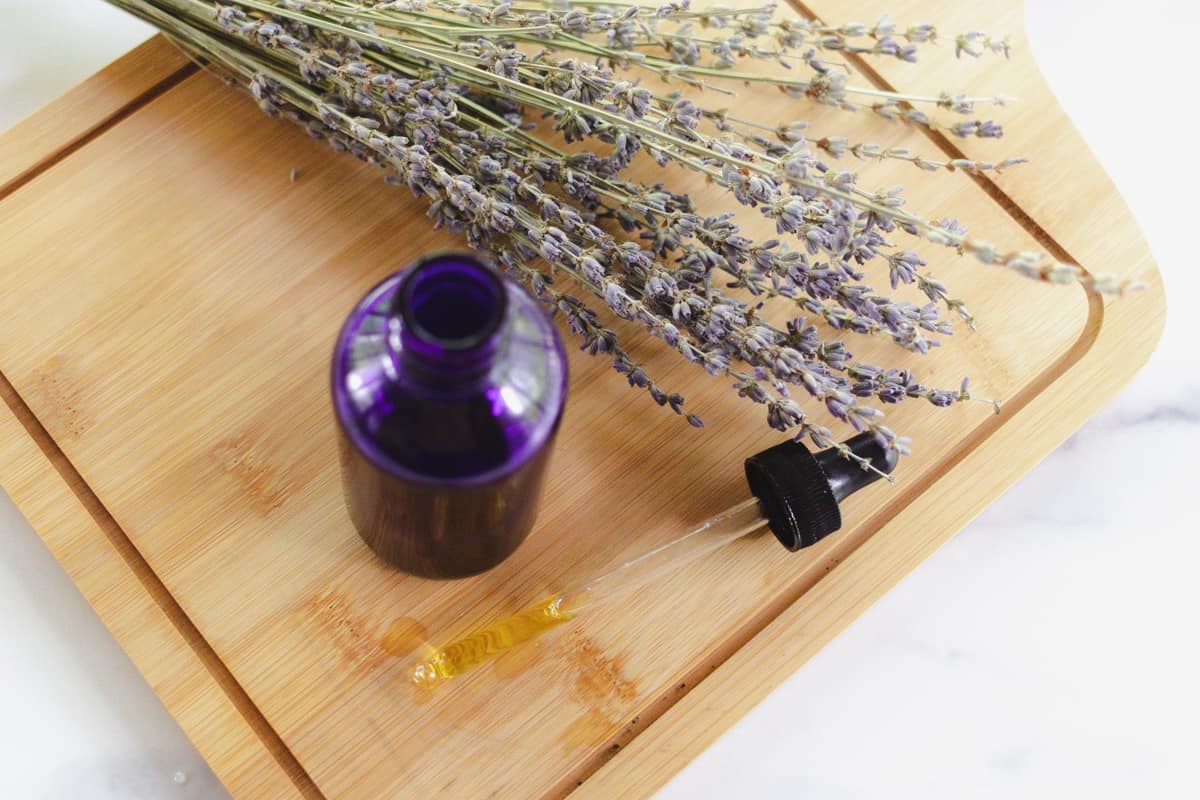 A bottle of homemade hair moisturizer with lavender sprigs alongside. 