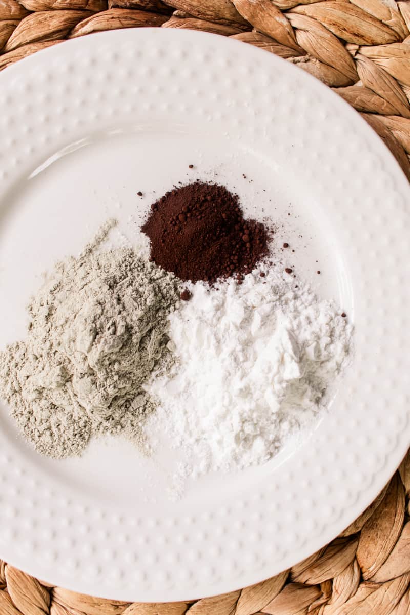 The ingredients to make your own dry shampoo out of cornstarch on a white plate.