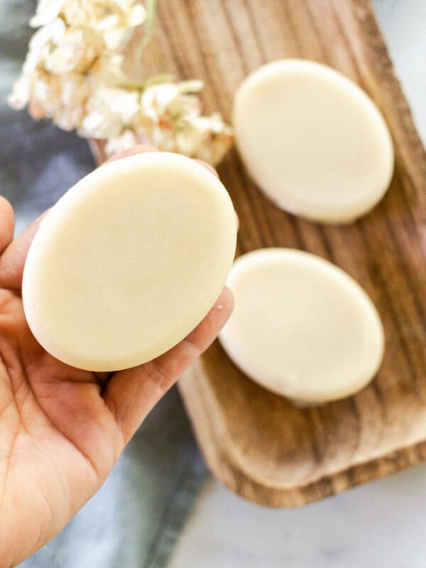 Holding a soap bar made from coconut milk.
