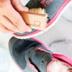 Cleaning mesh shoes with a shoe brush.