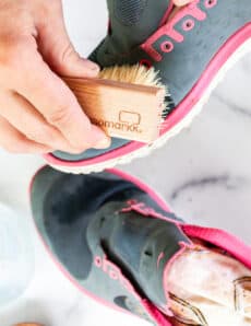 Cleaning mesh shoes with a shoe brush.