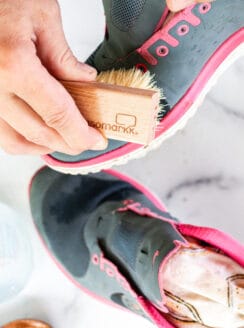 Cleaning mesh shoes with a shoe brush.
