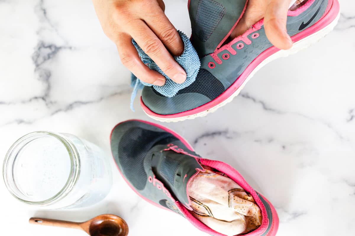 Wiping away any dirt and dust from clean workout shoes.